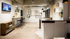 A modern kitchen with a wooden bar, bar stools, and a large island. - 109 Hostel Taipei (Taipei)