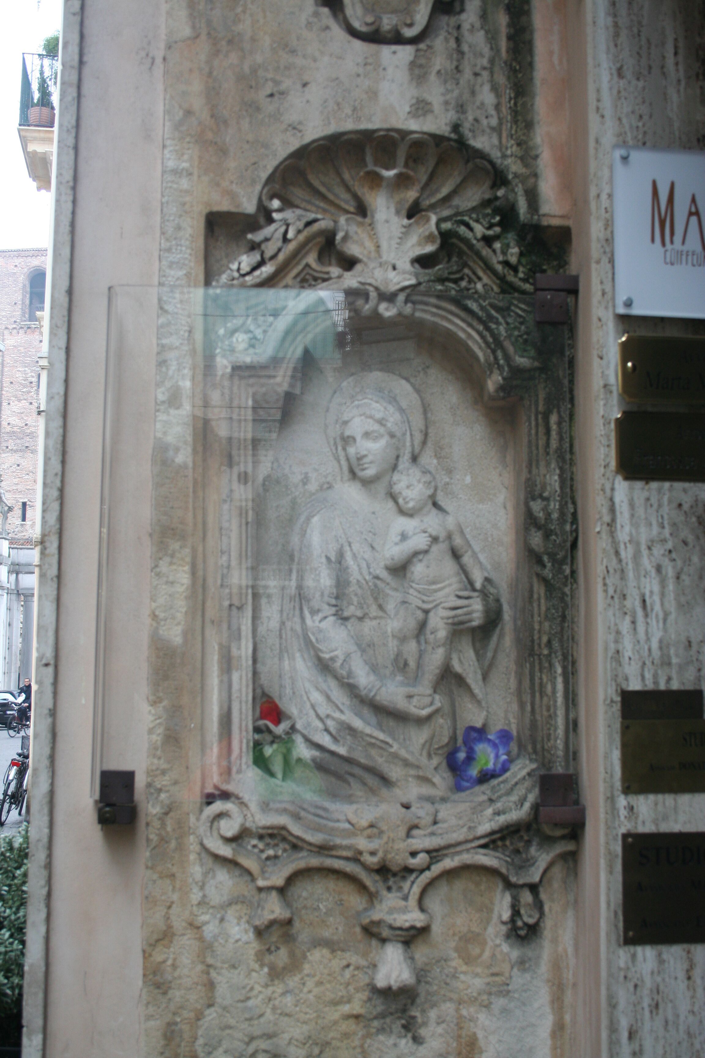 Un relieve pétreo de una figura religiosa, posiblemente un santo, con un niño.