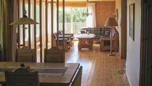 Interior acogedor de una cabaña con una mesa de comedor, sillas, un sofá y una mesita de centro.