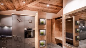 Une cuisine moderne avec des poutres en bois, des appareils électroménagers intégrés et un éclairage encastré.