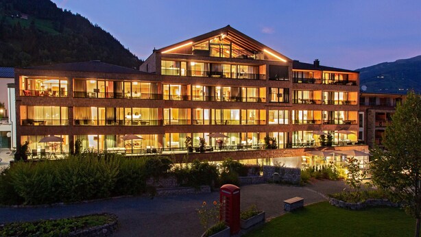 A multi-story hotel with balconies, a courtyard, and a mountain backdrop. - SR, Top 5 - Ap. 86m² mit 2 SZ, Terrasse 37 m² (Zell am See)