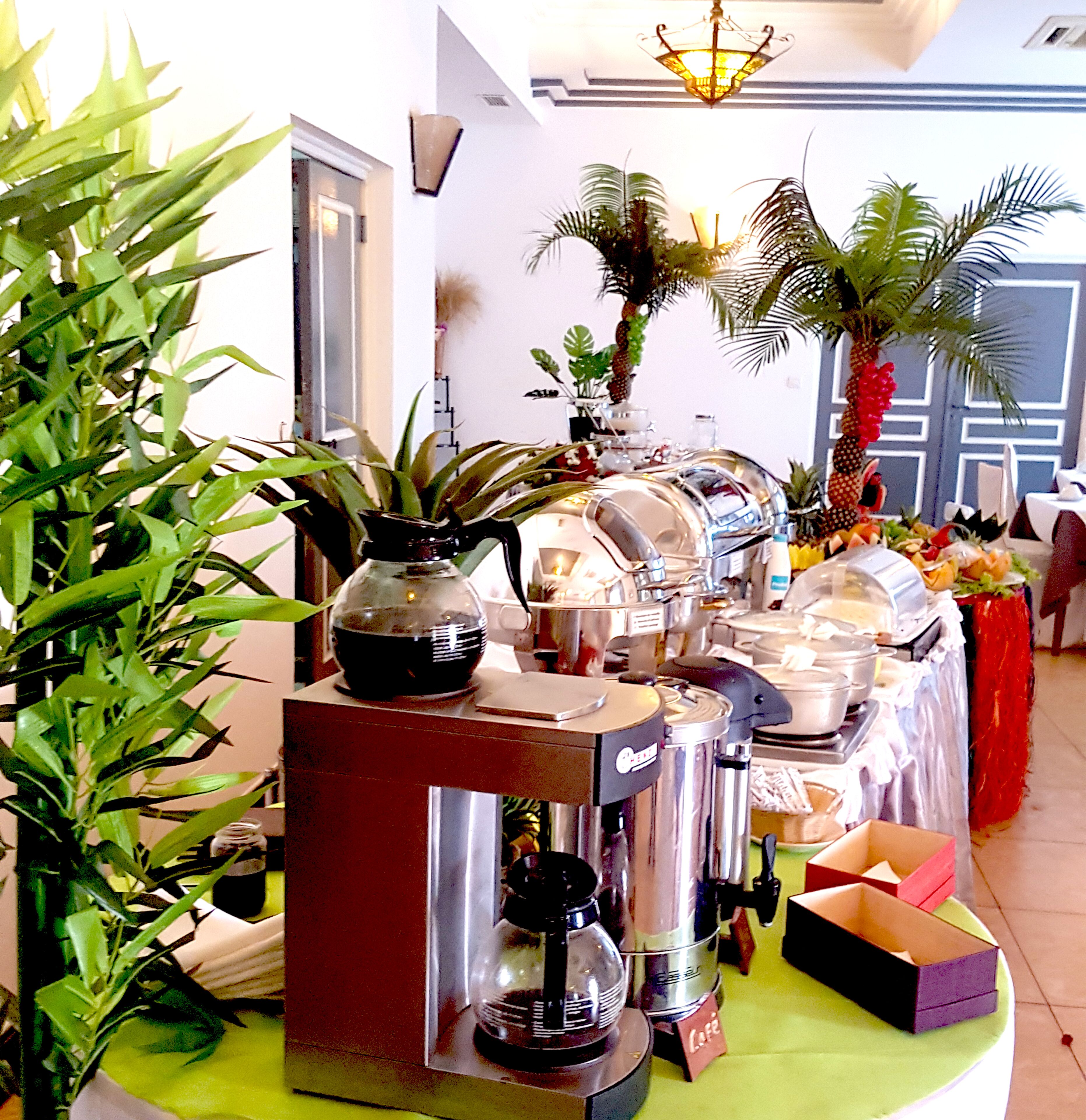 Ein reichhaltiges Buffet mit verschiedenen Speisenbehältern und einer Kaffeemaschine.