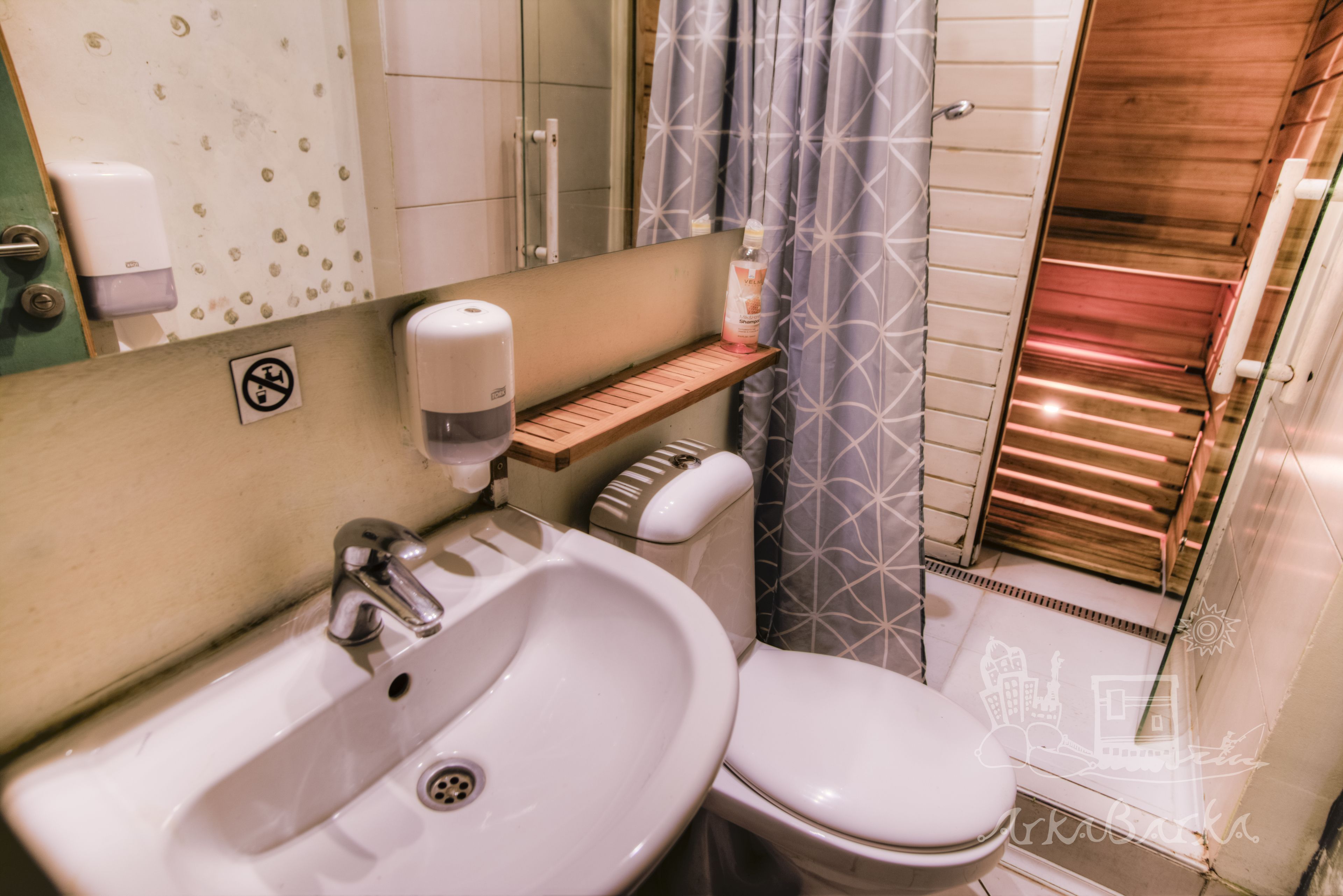 A bathroom with a sink, toilet, and shower area.