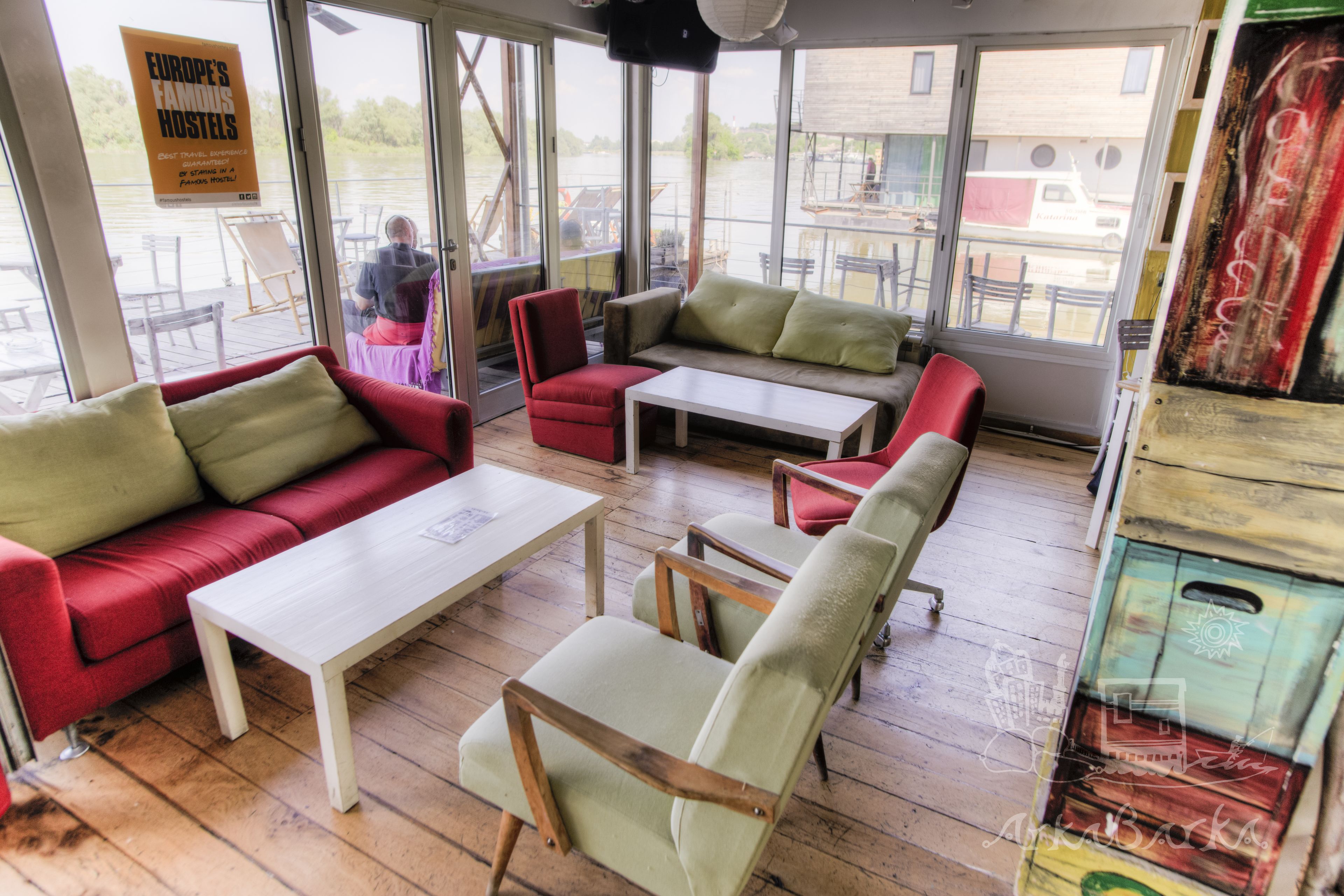 A cozy indoor seating area with a red sofa, a white table, and a green armchair.