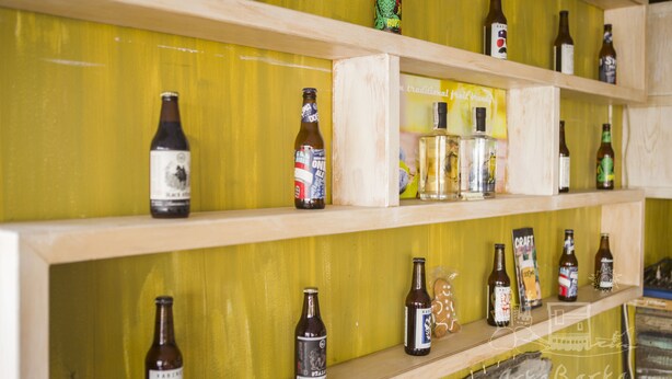 A shelf with various bottles of beer and a glass. - ArkaBarka Floating Hostel and Apartments (Belgrade)