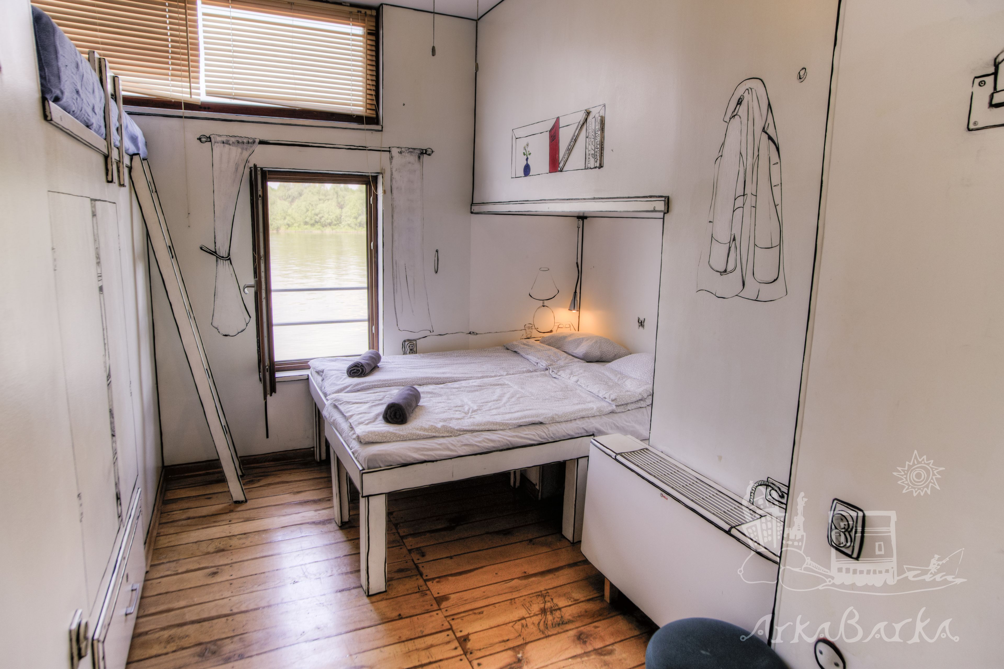 A small, compact room with a single bed, a window with blinds, a ladder, and a wall with a drawing.