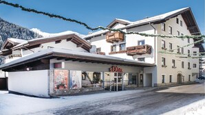 Un hotel de estilo alpino tradicional, con balcones de madera y un techo cubierto de nieve.