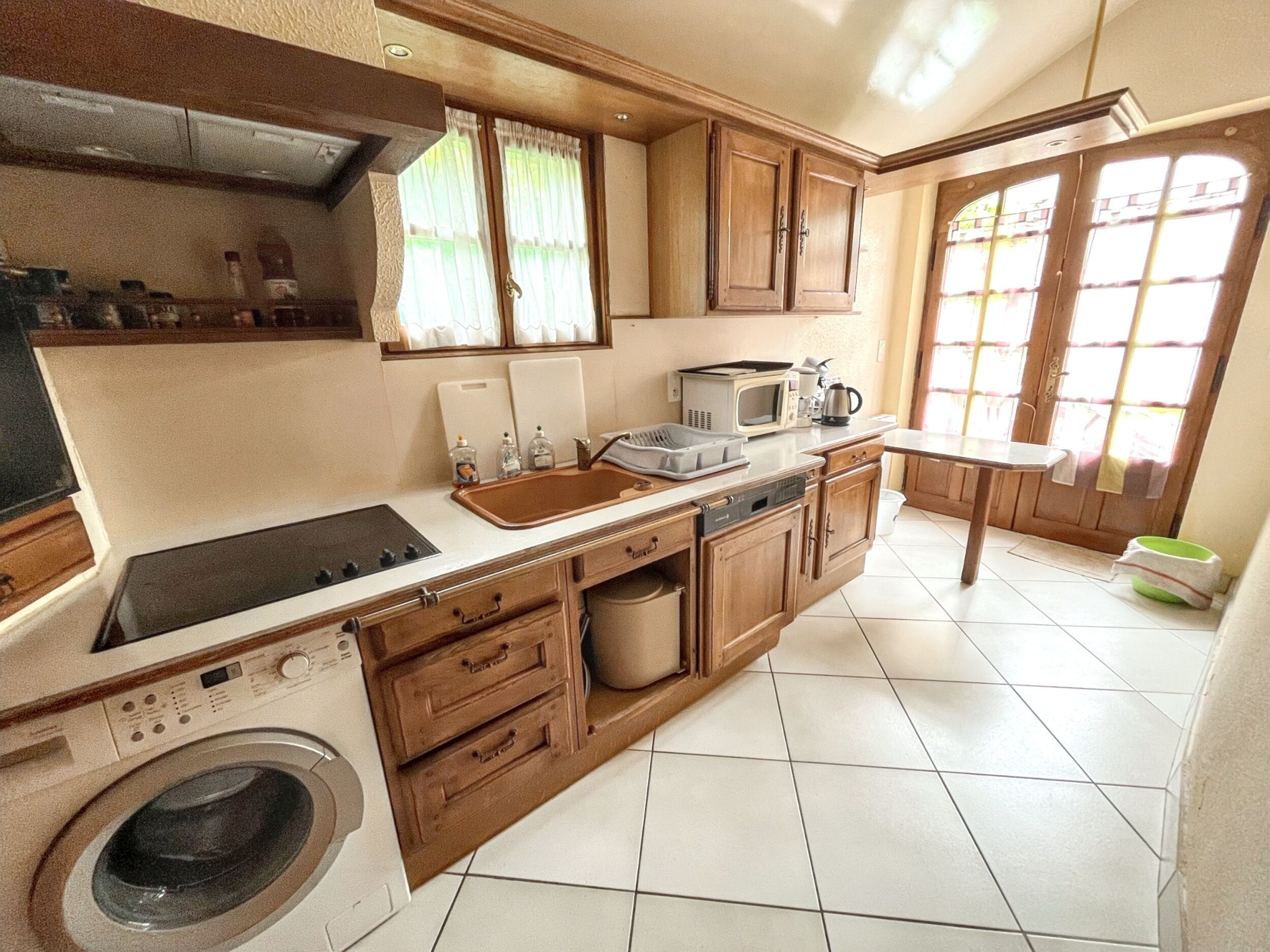 A compact kitchen with a built-in washer, a microwave, and a sink.
