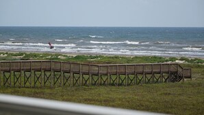 A wooden pier extending into the ocean with waves crashing against it. - Knot 4 Sail -Beach Front- Ocean Views- Front Row - 2BD/2BA. Sleeps 6 (Galveston)