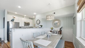 A modern kitchen with white cabinetry, a stainless steel refrigerator, and a microwave. - Knot 4 Sail -Beach Front- Ocean Views- Front Row - 2BD/2BA. Sleeps 6 (Galveston)
