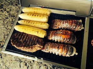 A grill with grilled corn, steak, and lobster on a kitchen counter. - Knot 4 Sail -Beach Front- Ocean Views- Front Row - 2BD/2BA. Sleeps 6 (Galveston)