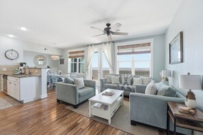 A spacious living room with a dining area, a kitchen, and a balcony with a view.