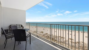 A balcony with a view of the beach, a table, and two chairs. - Lighthouse 608 - Great Location on the Gulf-Gulf Shores-Signature Properties (Gulf Shores)