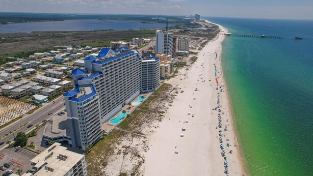 A coastal hotel with multiple high-rise buildings, a beach, and a pier. - Lighthouse 608 - Great Location on the Gulf-Gulf Shores-Signature Properties (Gulf Shores)