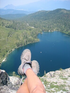 A person sitting on a rock overlooking a lake with mountains in the background. - Amazing property & Shasta views, private lake, dark skies, close to everything (Mt. Shasta)