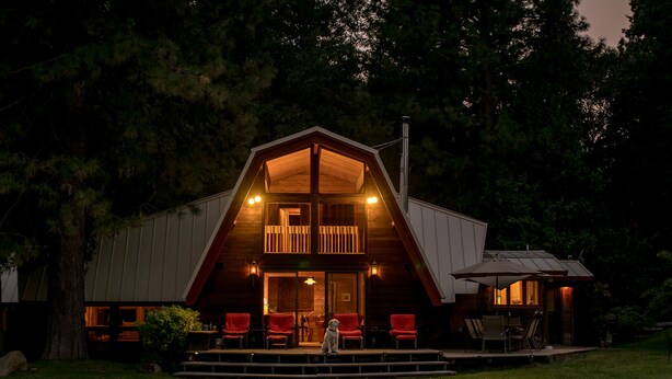 A large, two-story wooden cabin with a balcony, surrounded by trees. - Amazing property & Shasta views, private lake, dark skies, close to everything (Mt. Shasta)