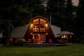 A large, two-story wooden cabin with a balcony, surrounded by trees. - Amazing property & Shasta views, private lake, dark skies, close to everything (Mt. Shasta)