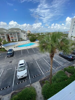 Guests can park their vehicles in designated spaces surrounded by lush greenery and enjoy access to a nearby pool.