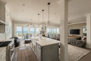Una cocina moderna con una isla grande, un comedor y vistas al océano.