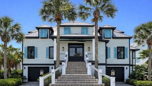A two-story house with a front staircase, a black door, and a garage. - OCEANFRONT / Sleeps 16 / BELLA VISTA / POOL / SPA / ELEVATOR / ELEGANT HOME (Isle of Palms)