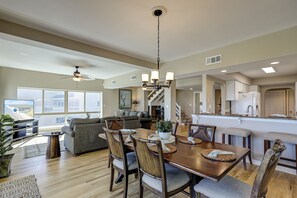 Un salón amplio con una gran mesa de comedor, asientos cómodos y vistas al exterior.