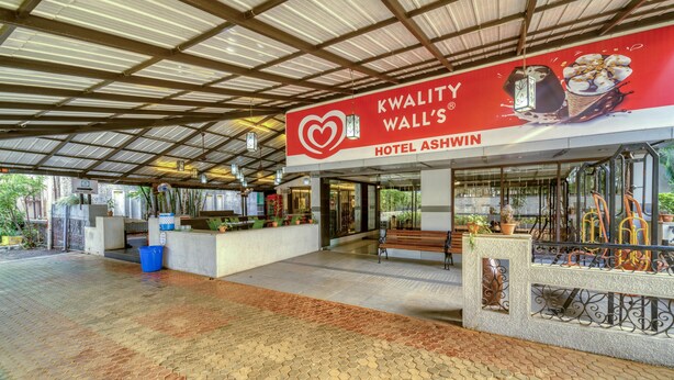 Un espacio al aire libre cubierto con un cartel que dice 'Kwality Wall's Hotel Ashwin'.