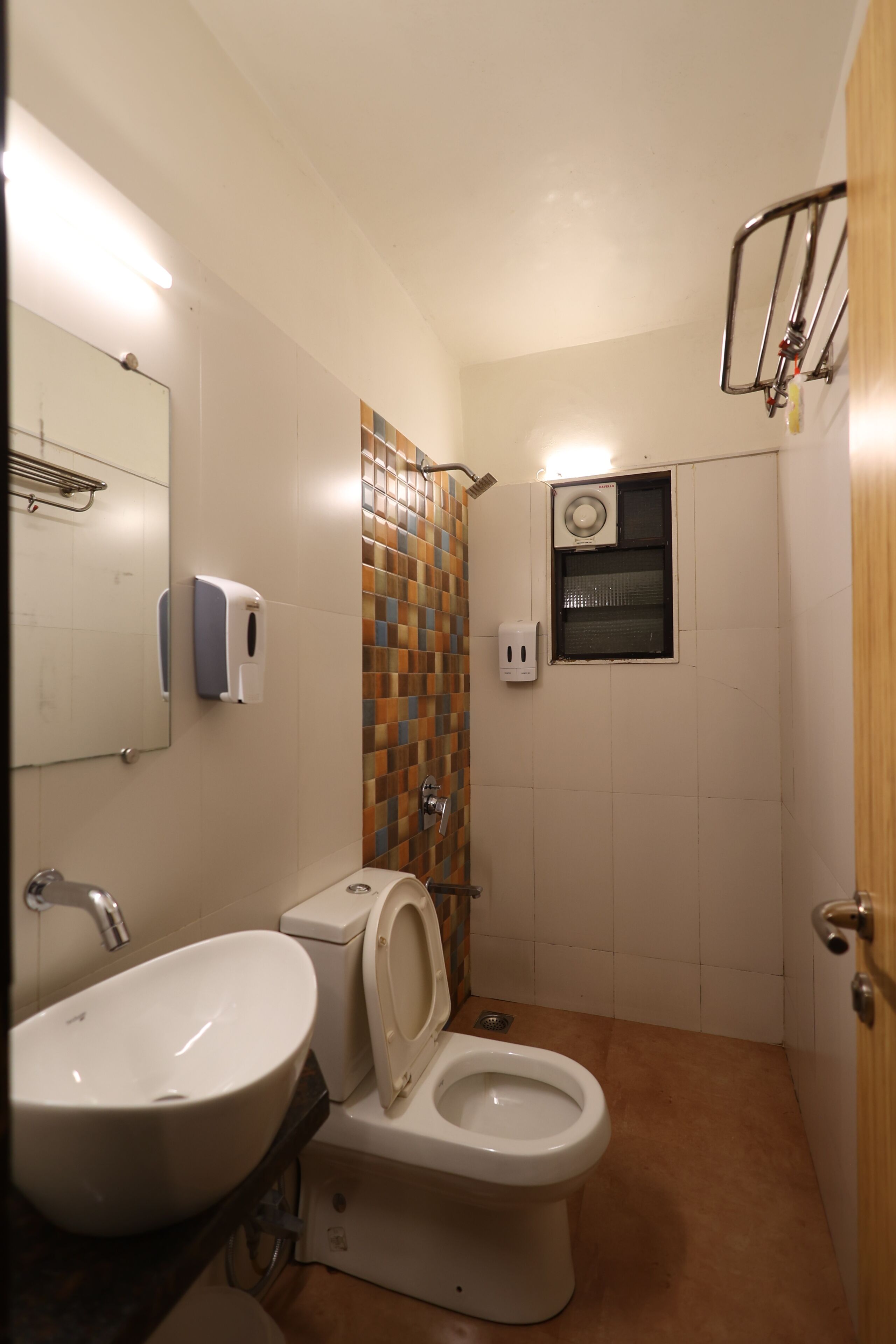 A compact bathroom with a sink, toilet, and shower.