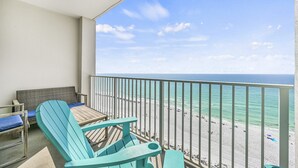 Un balcon avec vue sur une plage et l’océan.