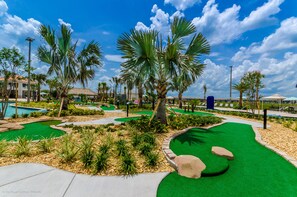 Enjoy a serene golfing experience amidst lush green spaces and palm trees.