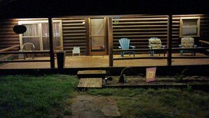 A log cabin with a deck area featuring outdoor seating and a small table. - LOG Cabin, 5 miles from town, but very country setting (Science Hill)