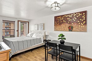 Une chambre à coucher avec un lit, une table de chevet, une lampe et un tableau au mur.