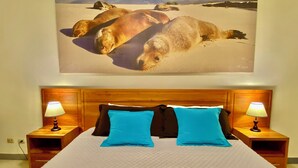 A bed with a wooden headboard, two blue pillows, and two bedside lamps. - This two-bedroom is a perfect island getaway. (Puerto Ayora, Santa Cruz Island)