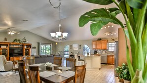 A spacious living room with a dining area, kitchen, and large windows. - Beautiful 3 bed 2 bath, Heated Pool, Minutes from the Ocean (Sebastian)