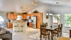 A spacious kitchen with wooden cabinets, a central island, and a dining area with a table and chairs. - Beautiful 3 bed 2 bath, Heated Pool, Minutes from the Ocean (Sebastian)