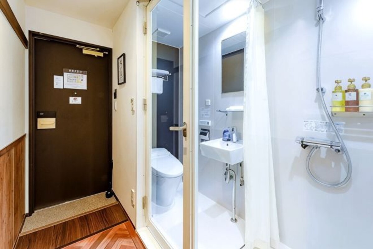 A bathroom with a toilet, sink, and shower.