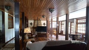 Una habitación amplia con vigas de madera en el techo, un sofá, una mesa y sillas.