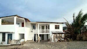 A two-story house with a balcony, a front porch, and a garage. - A.S.J. Backpackers Baler (Baler)