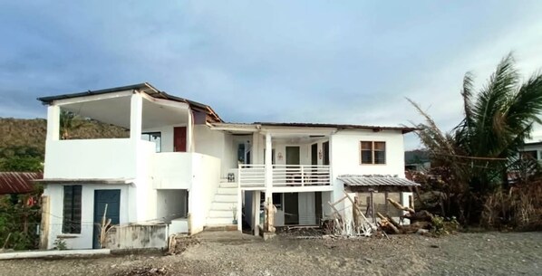 Una casa de dos pisos con balcón, porche delantero y garaje.
