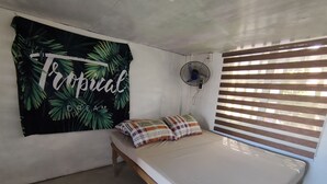 A room with a bed, a wall-mounted fan, and a window with blinds. - A.S.J. Backpackers Baler (Baler)