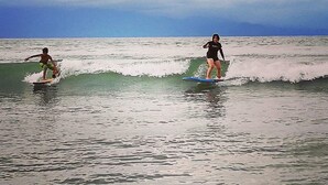 Two people surfing on waves in the ocean. - A.S.J. Backpackers Baler (Baler)