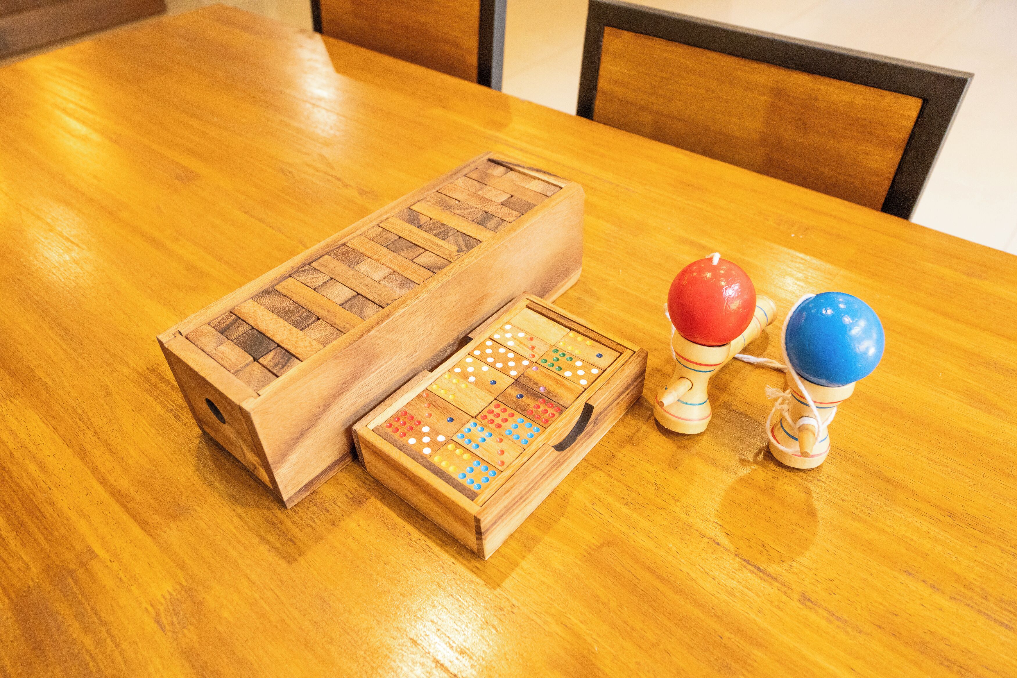 A wooden table with a board game and two wooden figurines.