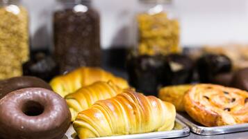 Una bandeja con diversos pasteles, incluyendo cruasanes y donas.