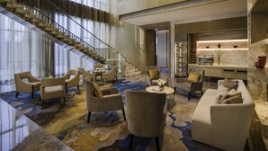 A spacious lobby with a high ceiling, a grand staircase, and a modern kitchen area. - InterContinental Jakarta Pondok Indah by IHG (Jakarta)