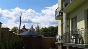 Un patio con sendero empedrado, bancos y un edificio con balcones.