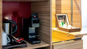 Una kitchenette equipada con microondas, cafetera y refrigerador pequeño.