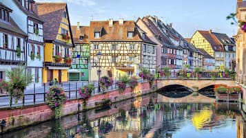A canal with traditional half-timbered houses on one side and a stone bridge in the middle.