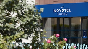 A hotel sign with the name "NOVOTEL SUITES" and a blue awning.