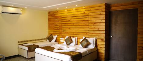 Una cama doble con cabecera de madera, una mesita de noche y un aire acondicionado de pared.