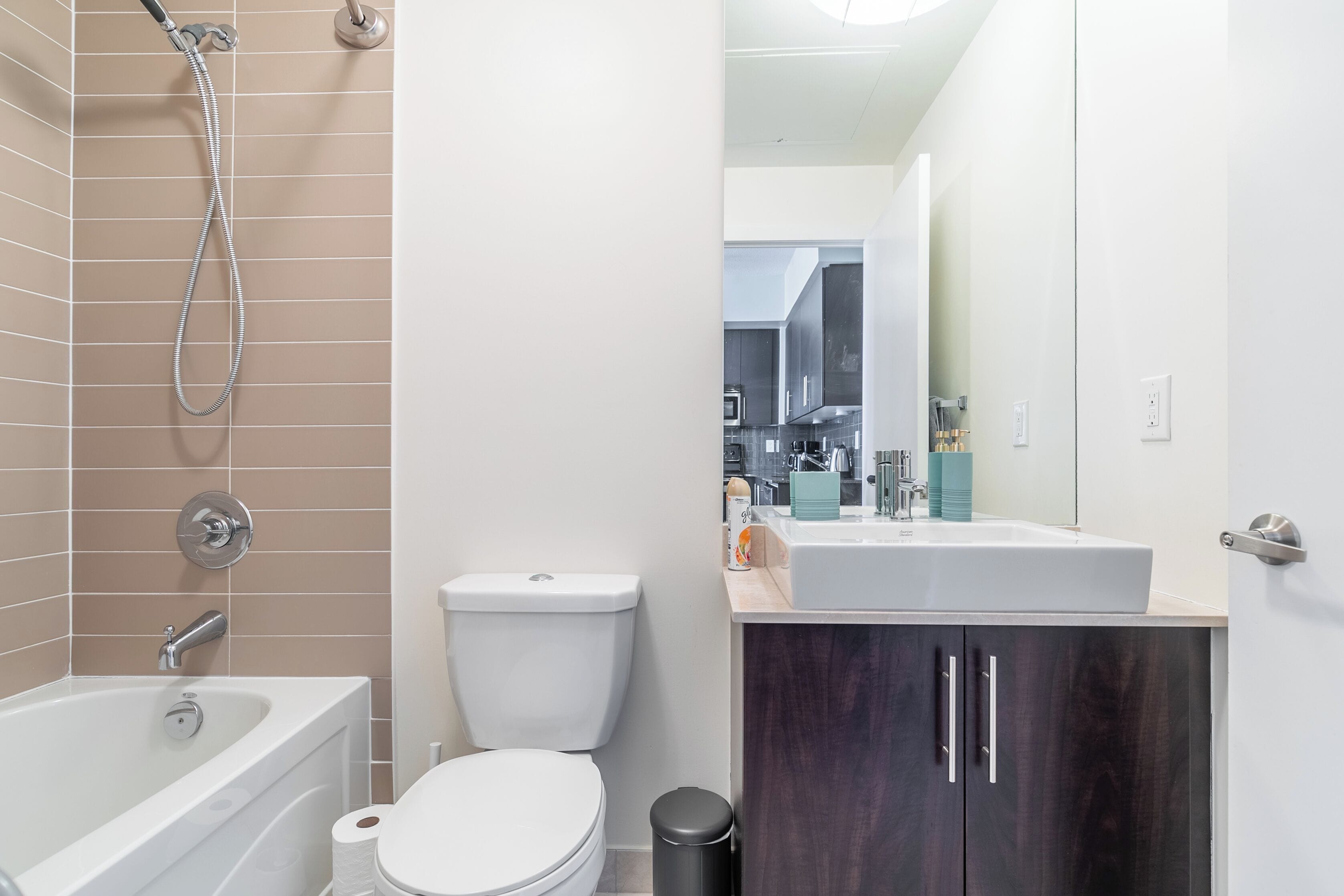 A modern bathroom with a bathtub, toilet, and sink.