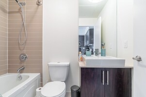 A modern bathroom with a bathtub, toilet, and sink.